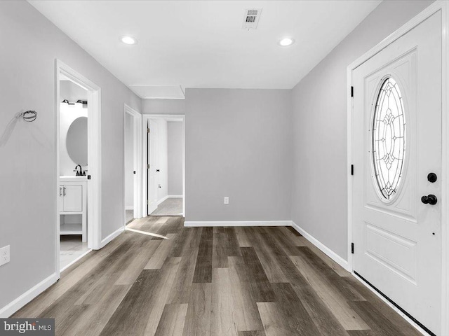 foyer entrance featuring baseboards, visible vents, wood finished floors, and recessed lighting