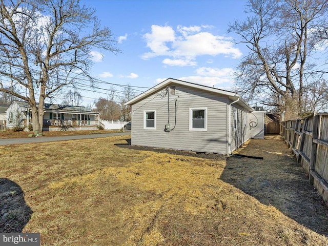 view of side of home featuring crawl space, a fenced backyard, and a lawn