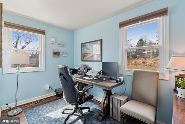 home office featuring plenty of natural light, baseboards, radiator heating unit, and wood finished floors