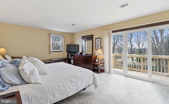 bedroom with access to exterior, visible vents, carpet floors, and multiple windows