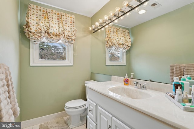 bathroom with toilet, vanity, a healthy amount of sunlight, visible vents, and tile patterned floors