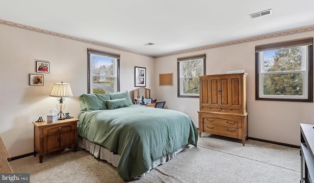 bedroom with wallpapered walls, baseboards, multiple windows, and visible vents