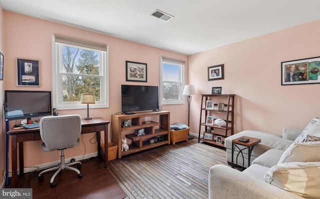 office with baseboards, visible vents, and hardwood / wood-style floors