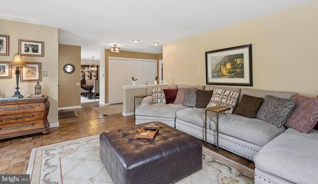 living area with an inviting chandelier and baseboards