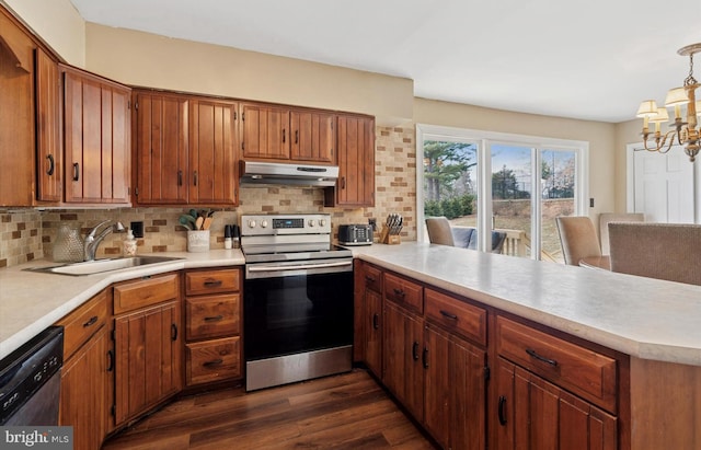 kitchen featuring under cabinet range hood, a peninsula, a sink, appliances with stainless steel finishes, and backsplash