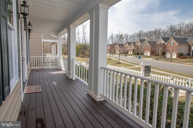 deck featuring covered porch and a residential view