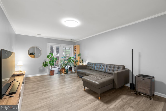 living area with baseboards, light wood finished floors, and crown molding