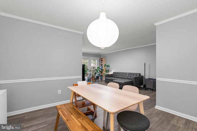 dining room with baseboards, ornamental molding, and wood finished floors