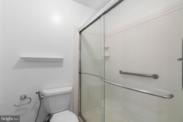 full bath featuring toilet and a shower with shower door