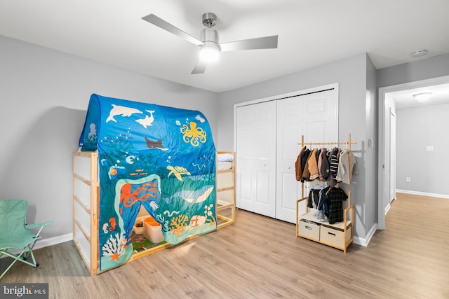 bedroom with ceiling fan, a closet, baseboards, and wood finished floors