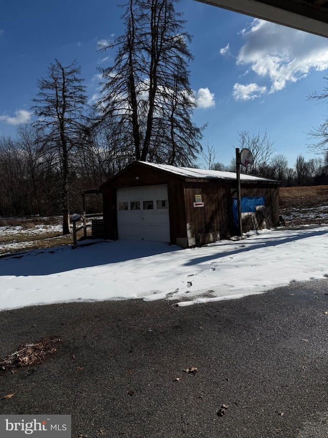 snow covered garage with a garage