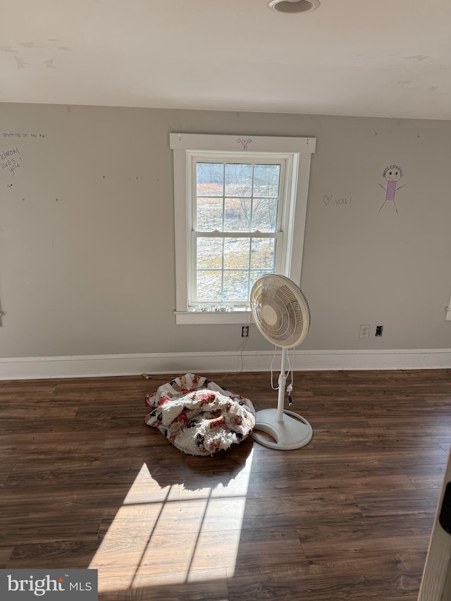 unfurnished room featuring baseboards and wood finished floors