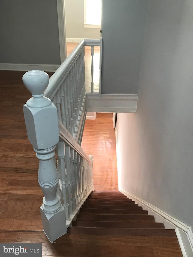 stairs featuring baseboards and wood finished floors