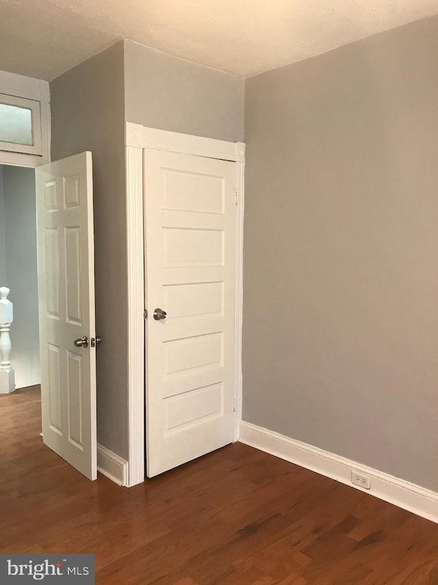 interior space featuring dark wood finished floors and baseboards