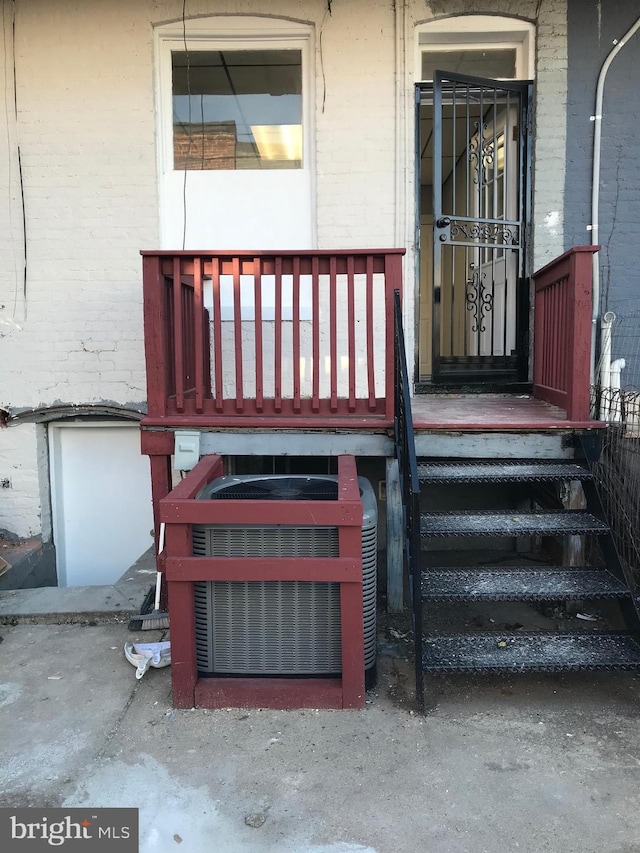 property entrance featuring central AC and brick siding