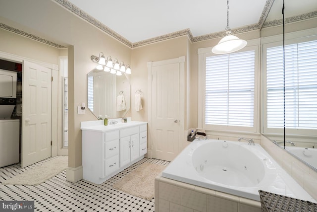 bathroom featuring stacked washer and dryer, a whirlpool tub, crown molding, and vanity