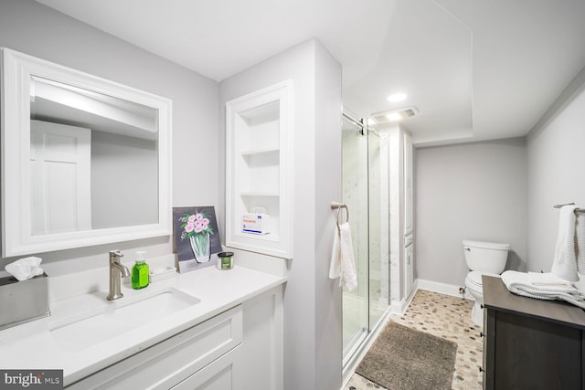 bathroom featuring vanity, toilet, baseboards, a stall shower, and visible vents