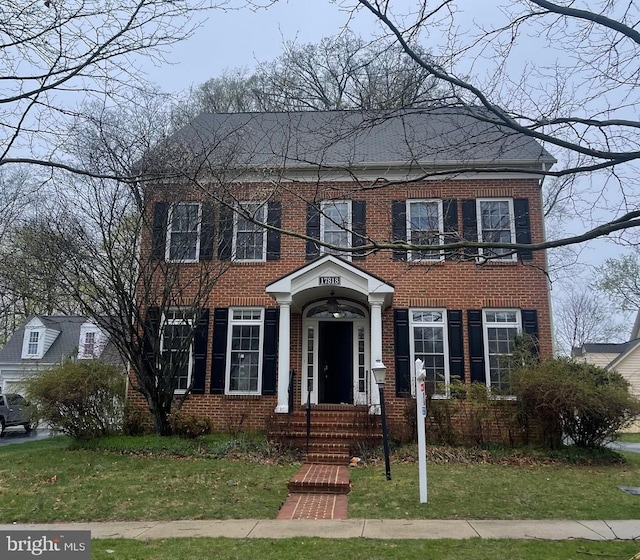 view of front of property featuring a front yard and brick siding