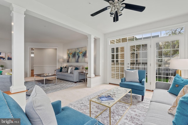 living room with decorative columns, a ceiling fan, and carpet floors