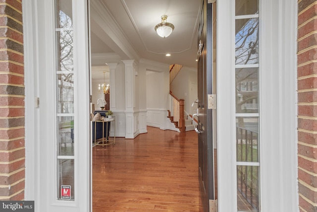interior space with an inviting chandelier, crown molding, recessed lighting, stairway, and wood finished floors