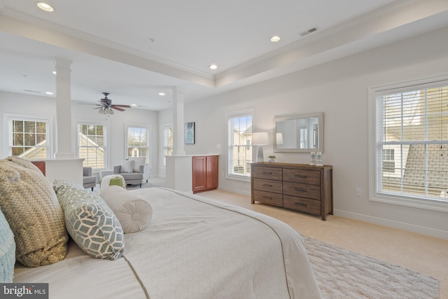 bedroom with light carpet, multiple windows, and ornate columns