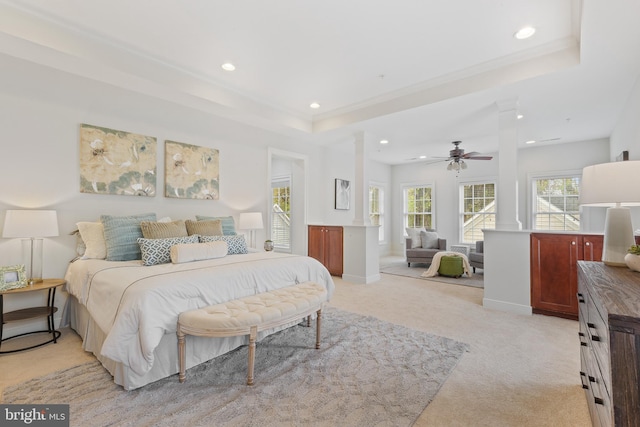 bedroom featuring baseboards, light carpet, recessed lighting, ornate columns, and a raised ceiling