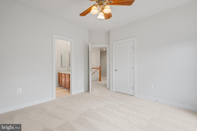 unfurnished bedroom with light carpet, baseboards, and connected bathroom