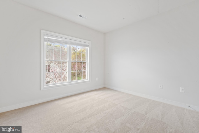 empty room with baseboards, visible vents, and carpet floors