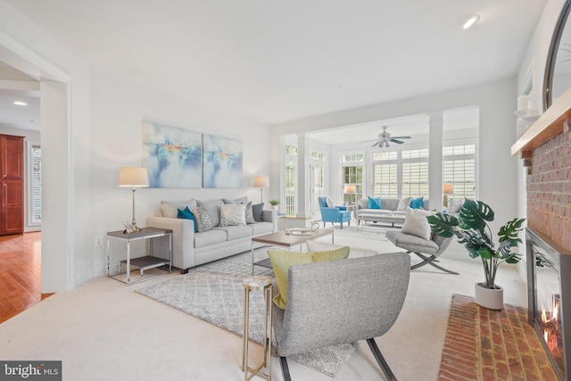 living room featuring recessed lighting, a brick fireplace, ornate columns, ceiling fan, and carpet