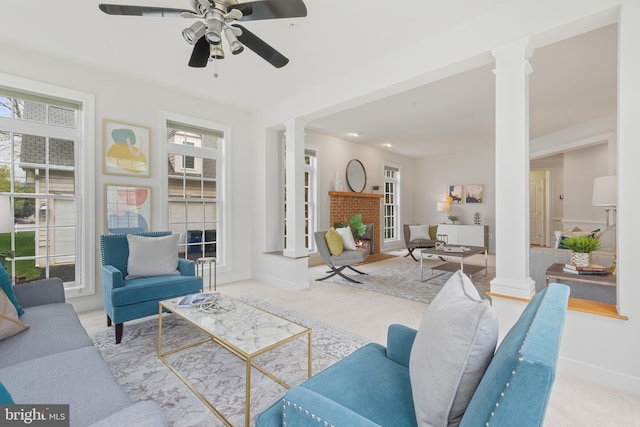 carpeted living area featuring ornate columns and a ceiling fan
