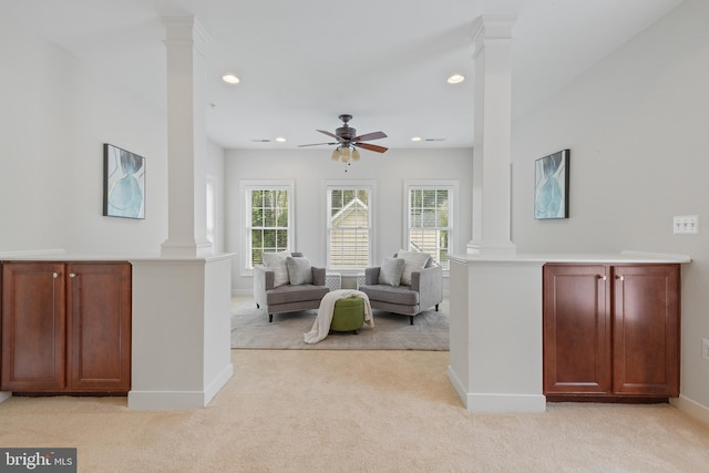 living room with ceiling fan, decorative columns, and light carpet