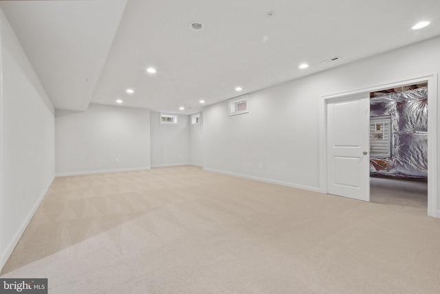 finished basement featuring light carpet, visible vents, and recessed lighting
