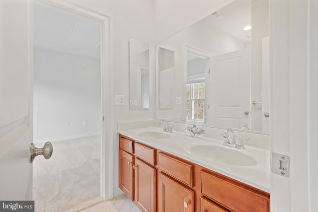 bathroom with double vanity, a sink, and visible vents