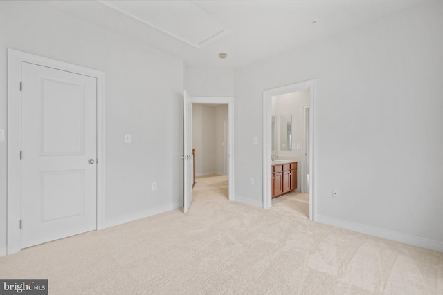 unfurnished bedroom featuring ensuite bath, light colored carpet, and baseboards