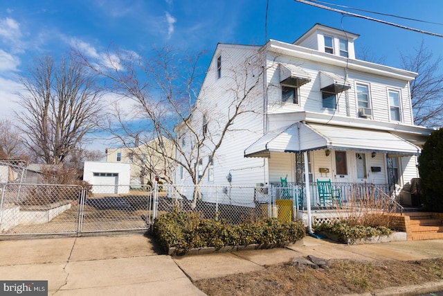 american foursquare style home featuring driveway, a gate, fence, and a porch