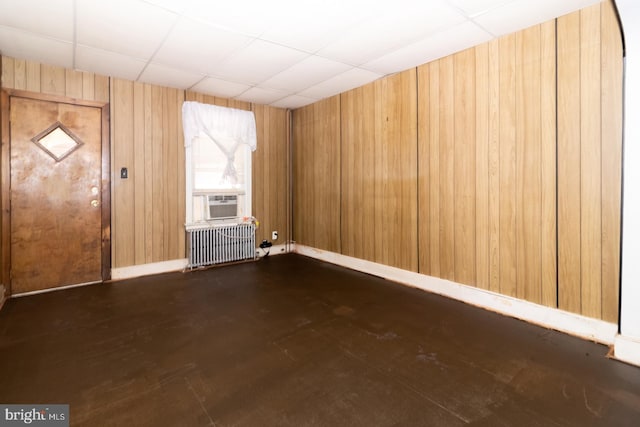 entryway with a paneled ceiling, radiator heating unit, wooden walls, cooling unit, and baseboards