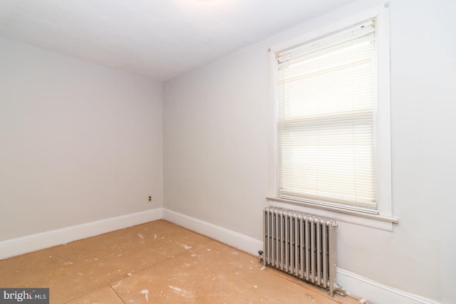 empty room featuring baseboards and radiator heating unit