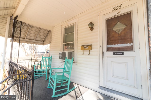 property entrance featuring a porch and cooling unit