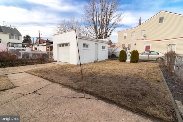 view of yard with an outdoor structure, fence, and a detached garage