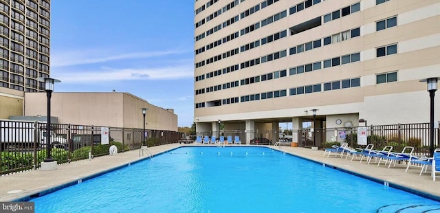 community pool featuring a patio area and fence