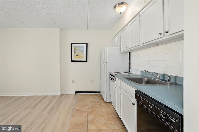 kitchen with black dishwasher, backsplash, white cabinets, a sink, and baseboards