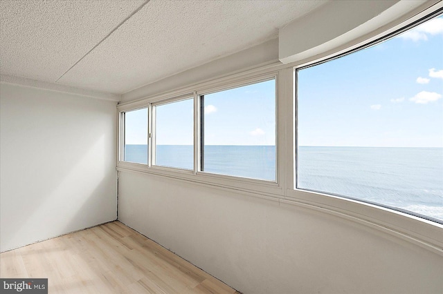 unfurnished sunroom featuring a water view