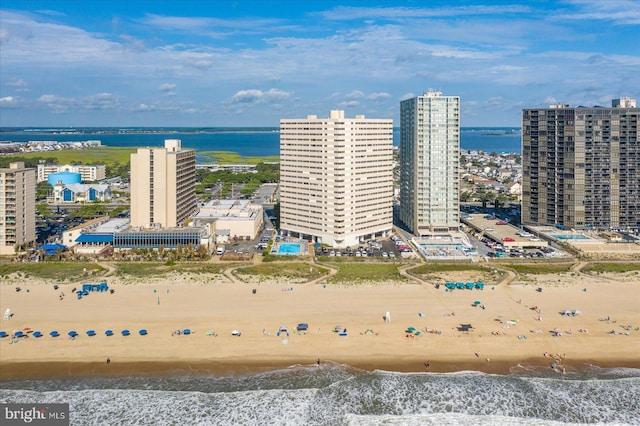 aerial view featuring a view of the beach, a water view, and a city view