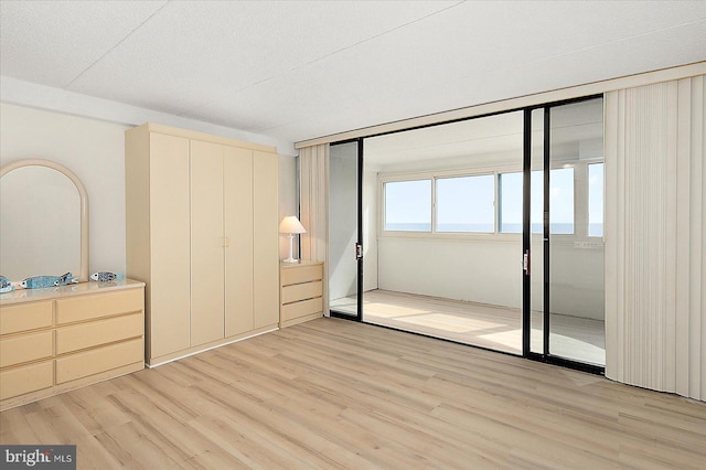 unfurnished bedroom with light wood-style flooring and a closet