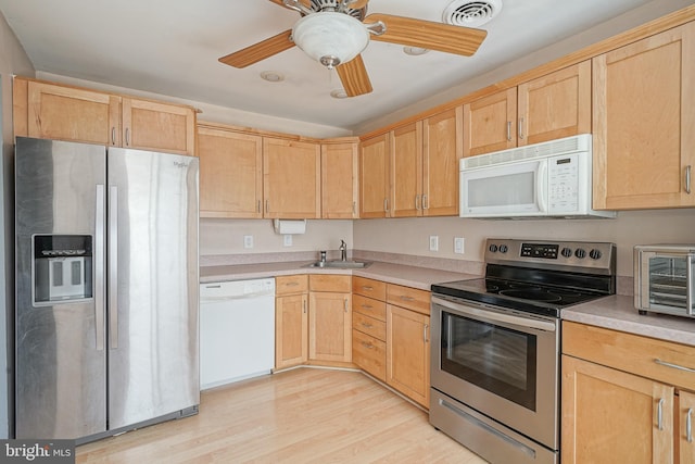 kitchen with light brown cabinets, visible vents, light wood finished floors, a sink, and appliances with stainless steel finishes