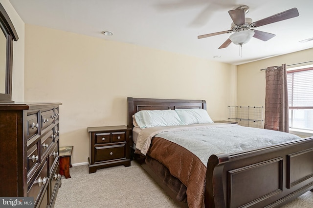 bedroom featuring visible vents, light colored carpet, baseboards, and a ceiling fan