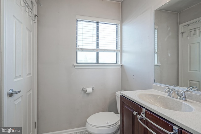 bathroom with vanity, toilet, and baseboards