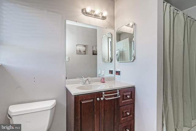 bathroom with vanity, a shower with shower curtain, and toilet