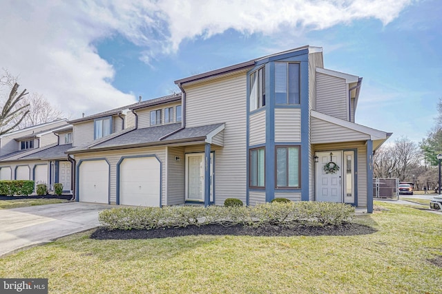 townhome / multi-family property with a garage, a front yard, and driveway