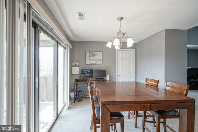 dining space with visible vents, light colored carpet, and an inviting chandelier